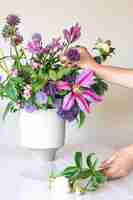 Foto gratuita vaso con fiori freschi d'estate in mani femminili su sfondo bianco