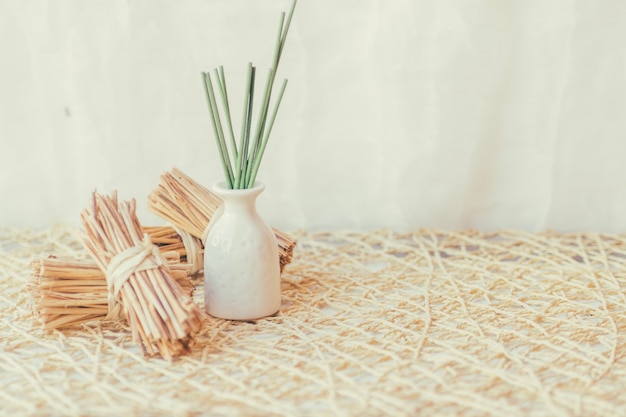 Vase with sticks near bunches of sticks