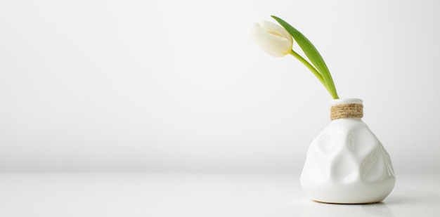 Free photo vase with tulip on desk