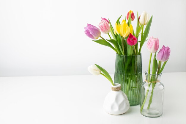 Vase with tulips on table