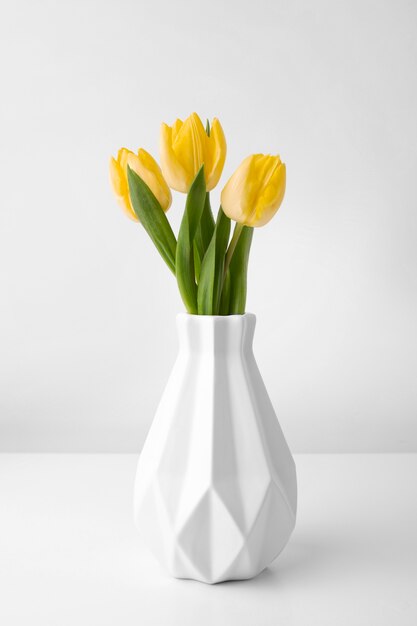 Vase with tulips on table