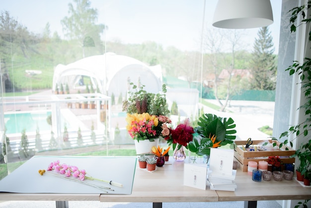 Vases with flowers and boxes with decor stand on a table