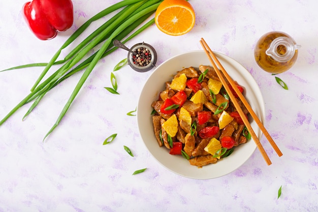 Veal fillet - stir fry with oranges and paprika in sweet and sour sauce on a light table. Flat lay. Top view