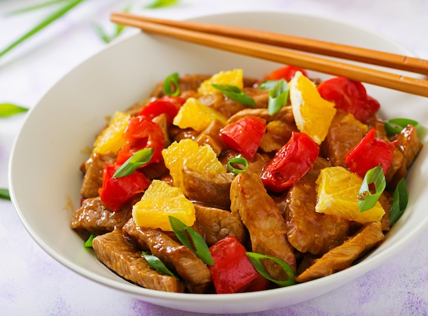 Veal fillet - stir fry with oranges and paprika in sweet and sour sauce on a light table