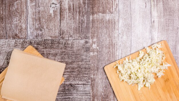 Vegan cabbage salad on wooden board next to an empty board