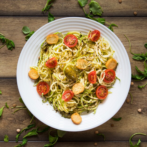 Vegan pasta in plate on wooden background