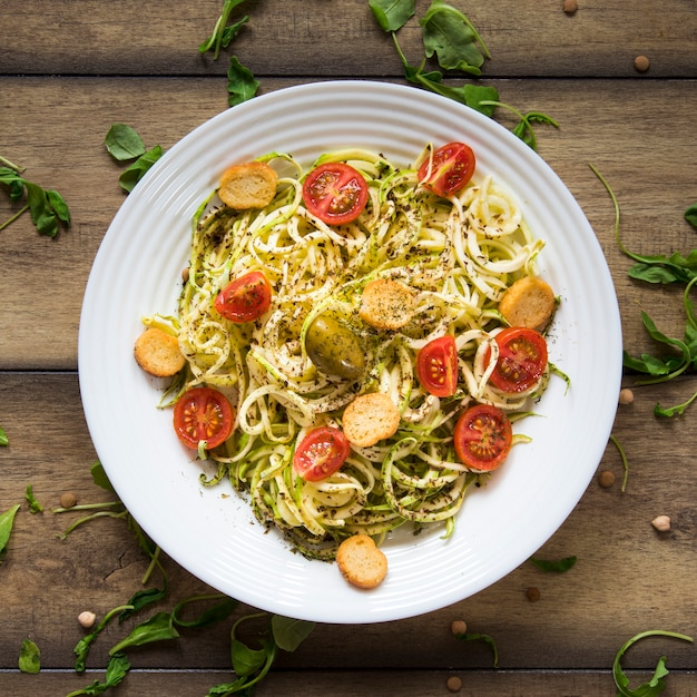 Vegan pasta in plate on wooden background
