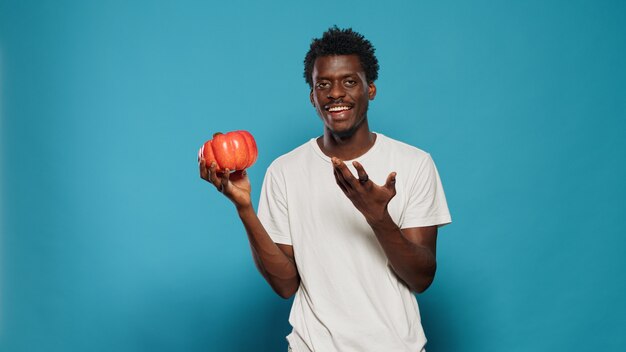 Vegan person holding red bell pepper in hand to cook