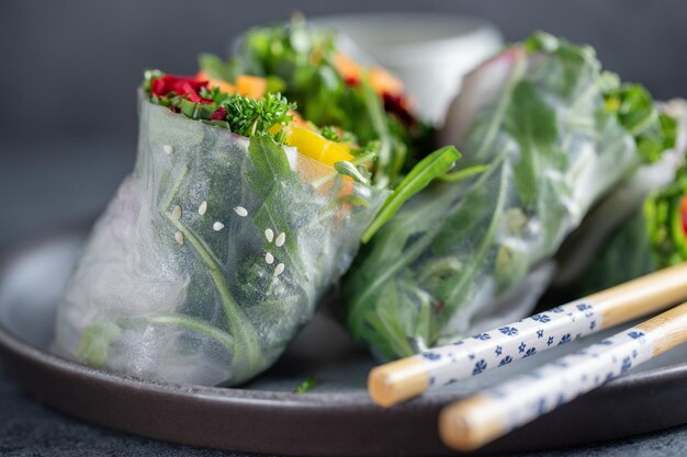 Vegan rice paper rolls with vegetables and sesam served on plate ready to eat