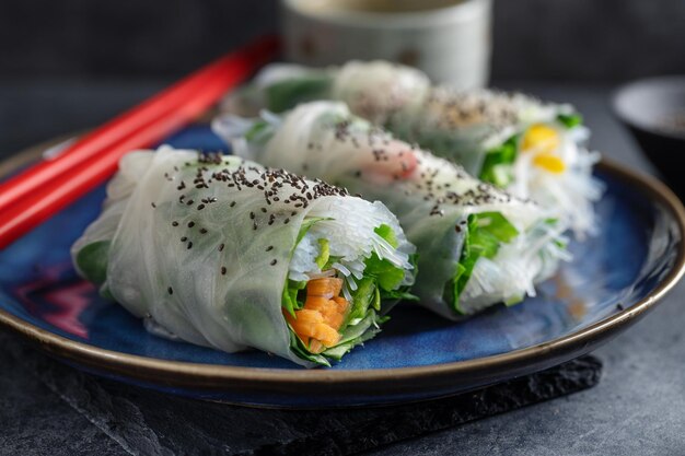 Vegan rice paper rolls with vegetables and sesam served on plate ready to eat