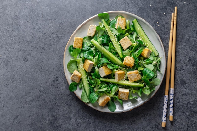 Insalata vegana con tofu, cetriolo e sesamo servito sul piatto primo piano