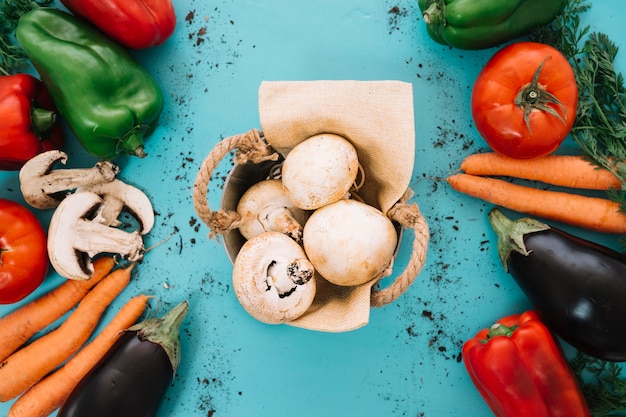 Vegetable composition with basket of mushrooms in middle