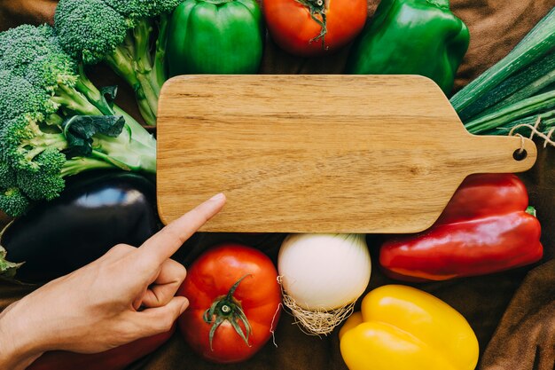 Vegetable composition with finger pointing towards board