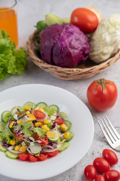 Овощной и фруктовый салат на белом фоне.