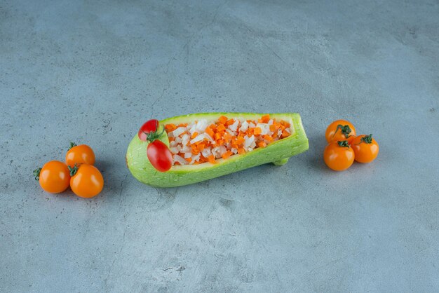Vegetable salad in a carved zucchini on blue.