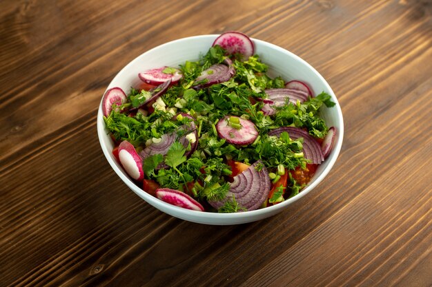 Vegetable salad fresh colored on the wooden surface