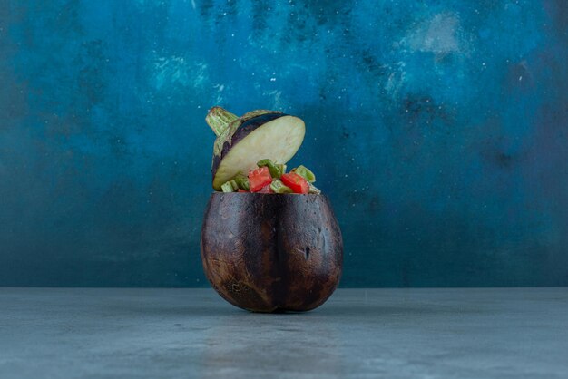 Vegetable salad inside a carved purple eggplant.