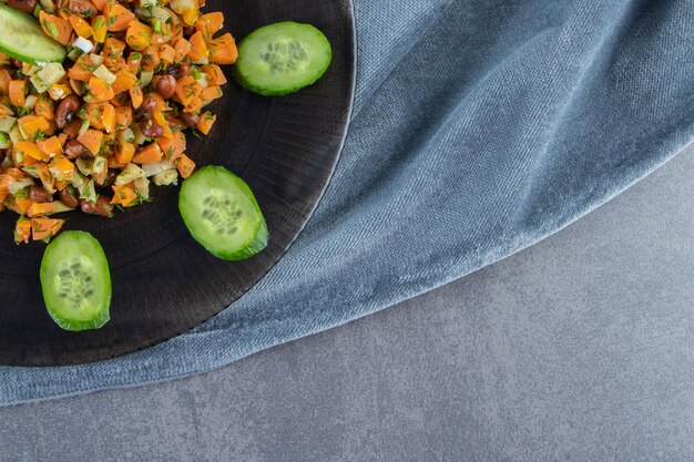 Vegetable salad on a plate on a towel on the marble surface