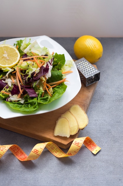 Vegetable salad on plate with measuring tape