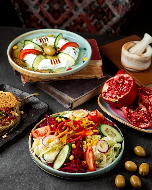 Vegetable salad and plate with pomegranates