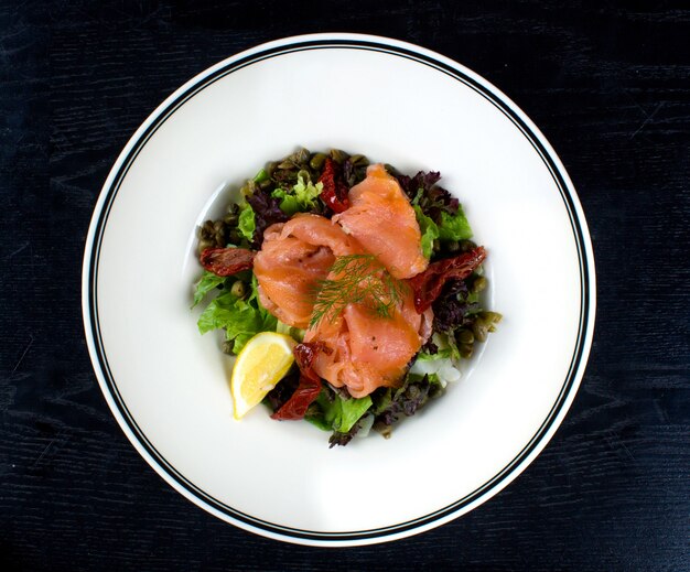 Vegetable salad topped with smoked salmon