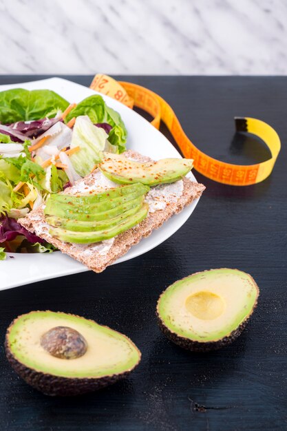 Vegetable salad with avocado on crisp bread on table 