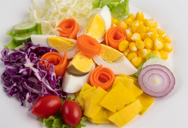 白い皿にゆで卵と野菜のサラダ。