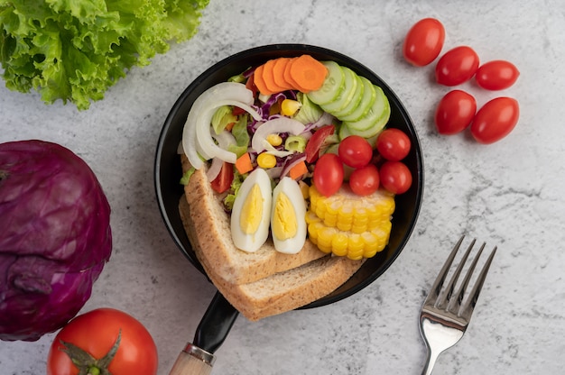 Vegetable salad with bread and boiled eggs in the pan.