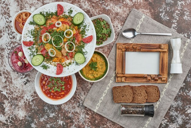 Vegetable salad with foods in ceramic dishes.