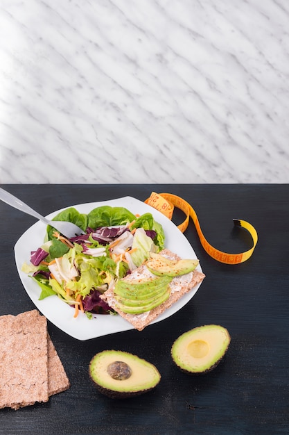 Vegetable salad with green avocado on crisp bread