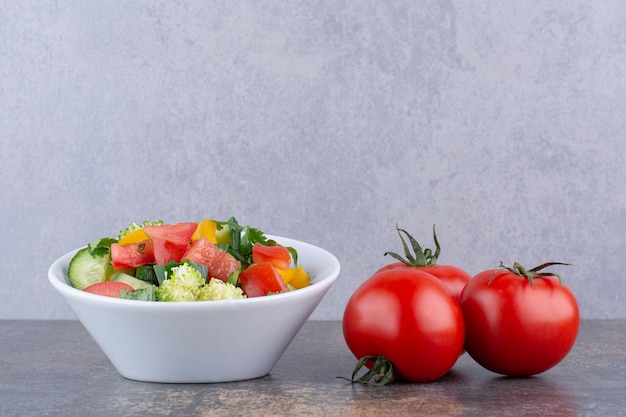 プレートにハーブと赤いトマトの野菜サラダ