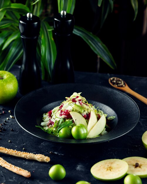 Vegetable salad with herbs and sliced apple