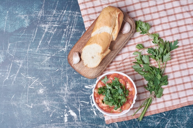 Vegetable salad with herbs and spices served with baguette.