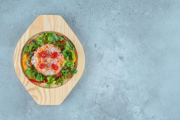 Vegetable salad with herbs in a wooden platter.