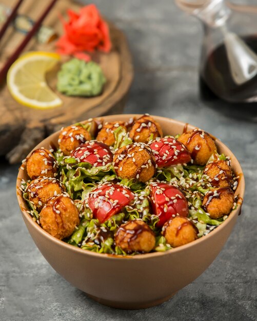Vegetable salad with meatballs, tomato,and herbs inside bamboo bowl.