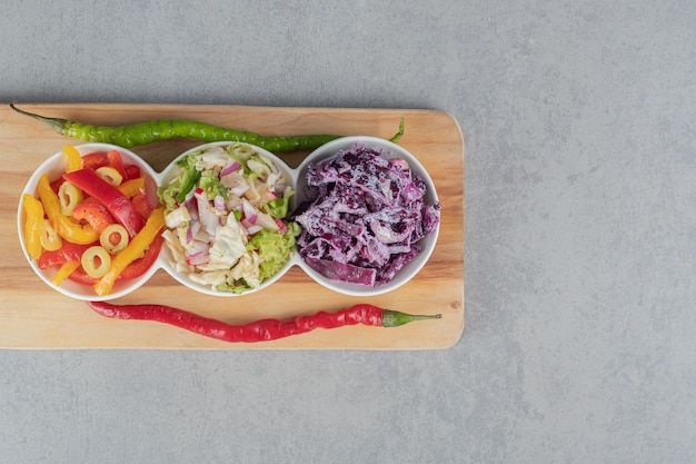 Vegetable salad with mixed ingredients on a wooden board.