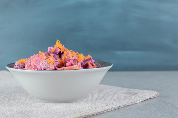 Vegetable salad with purple beetroots and orange chopped carrots mixed with sour cream.