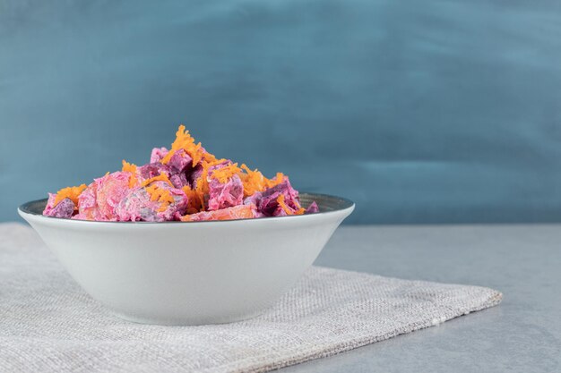 紫のビートルートとオレンジのみじん切りにんじんをサワークリームと混ぜた野菜サラダ。