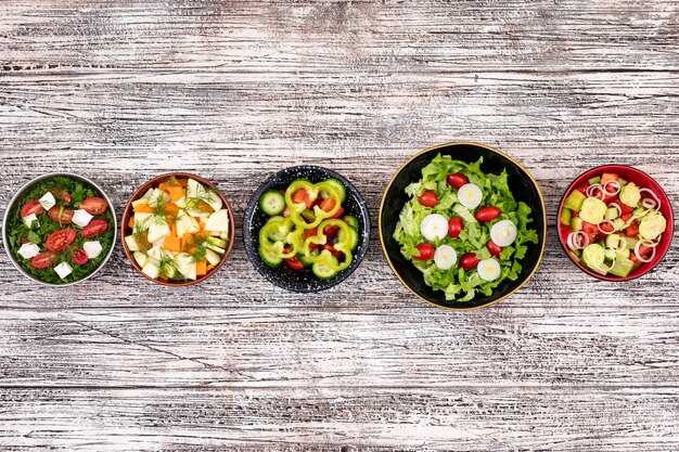 Vegetable salads on wooden surface top view