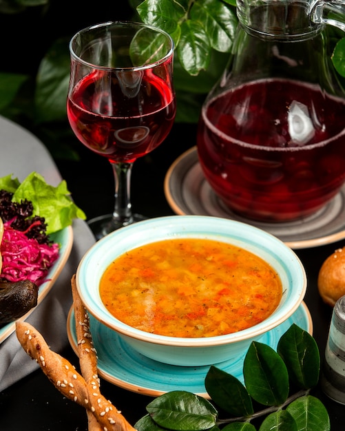 vegetable soup with pickled cabbage eggplant compote and breadsticks on table