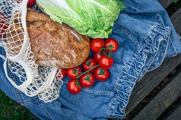 ショッピングバッグのピクニックの概念の野菜とパン
