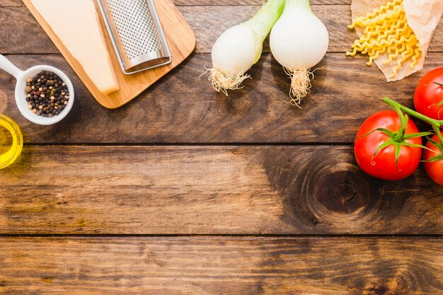 Vegetables and cheese near pasta and spices