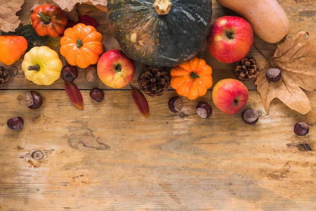 Free photo vegetables and dry leaves on wood board