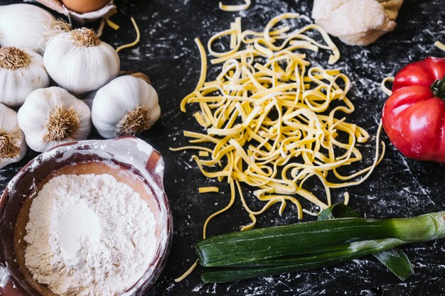 Vegetables and flour near pasta