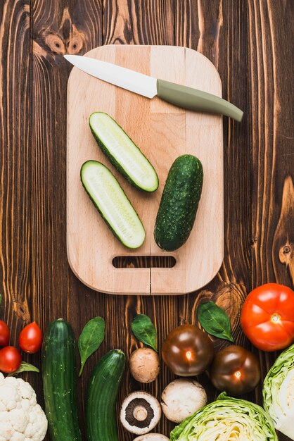 Vegetables lying near cut cucumber