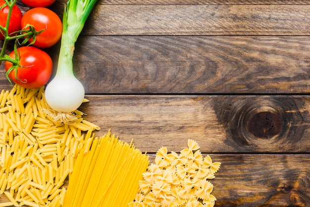 Vegetables lying near raw pasta