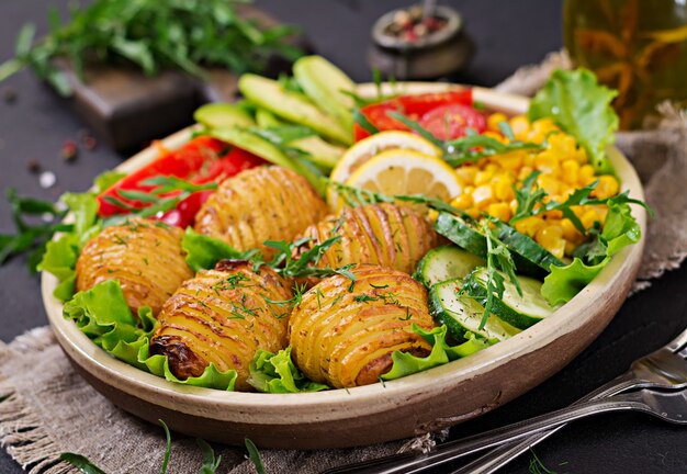 Vegetarian buddha bowl. Raw vegetables and baked potatoes in  bowl. Vegan meal. Healthy and detox food concept.