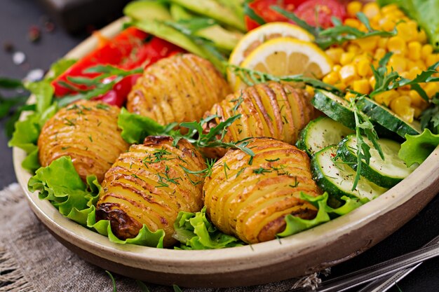 Vegetarian buddha bowl. Raw vegetables and baked potatoes in  bowl. Vegan meal. Healthy and detox food concept.