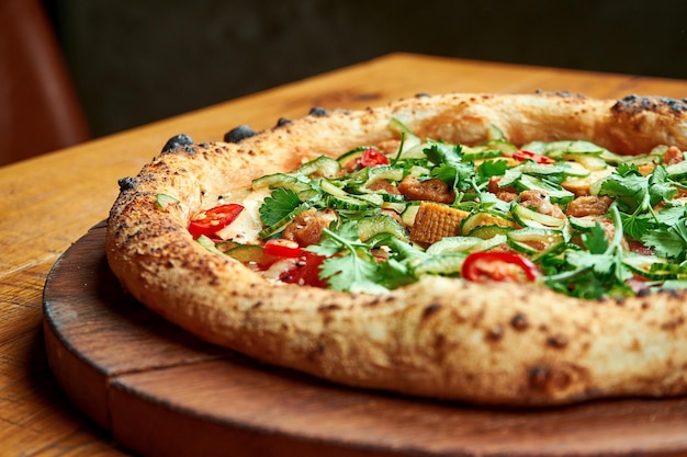 Вегетарианская пицца с тофу и овощами на деревянной доске на деревянном фоне Premium Фотографии