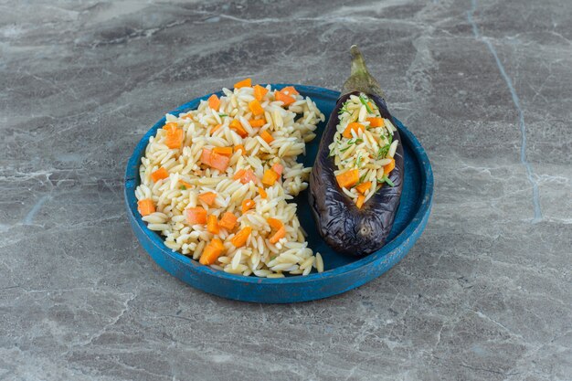 Vegetarian rice in eggplant, on the plate , on the marble table. 